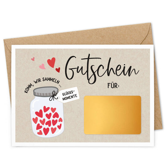 Rubbelgutschein Glücksmomente mit kreativem Design, goldfarbenem Rubbelfeld und Umschlag.