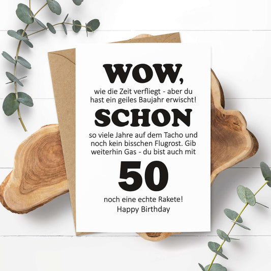 Postkarte zum 50. Geburtstag mit witzigem Spruch und Umschlag auf natürlichem Hintergrund.