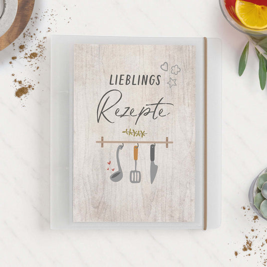 Ordner Lieblingsrezepte auf Küchentisch mit Zutaten