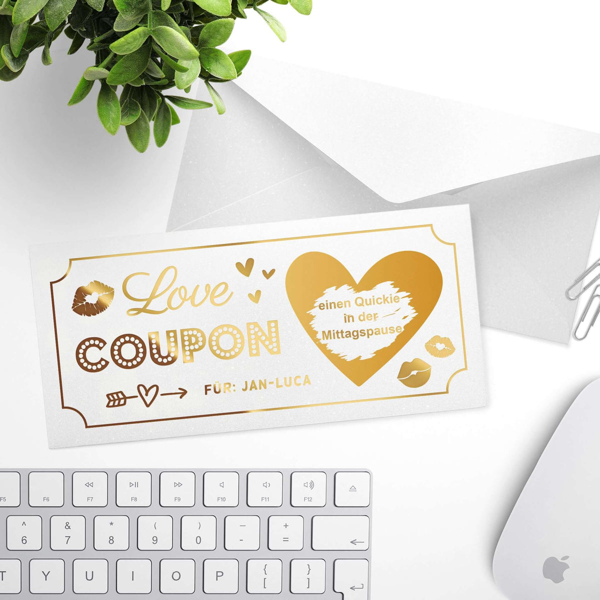 Weißer personalisierter Love Coupon mit goldener Folierung und Umschlag im Hintergrund