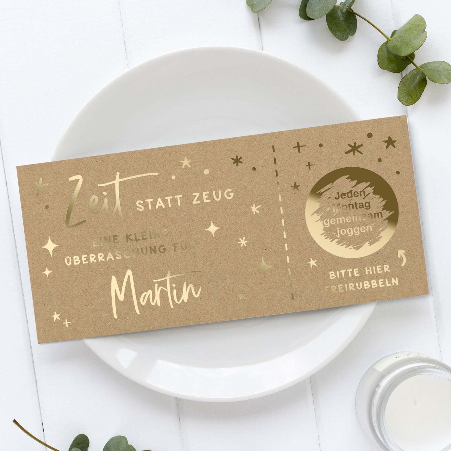 Rubbelgutschein personalisiert für Martin mit dem Text "Zeit statt Zeug" auf einem Teller.