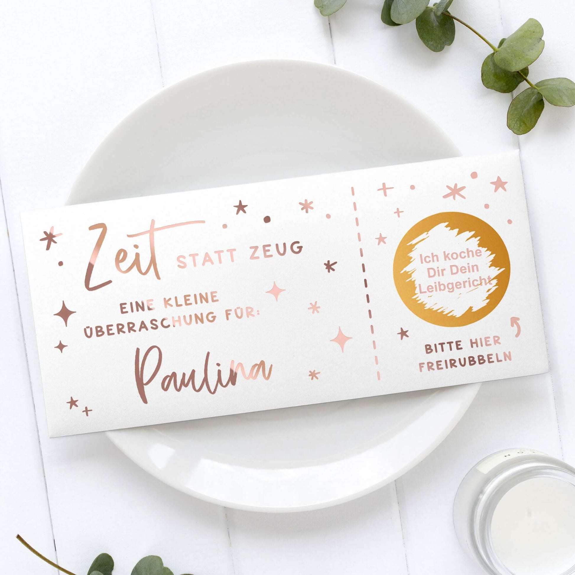 Rubbelgutschein personalisiert mit dem Text "Zeit statt Zeug" für Paulina auf einem Teller.