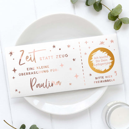 Rubbelgutschein personalisiert mit dem Text "Zeit statt Zeug" für Paulina auf einem Teller.