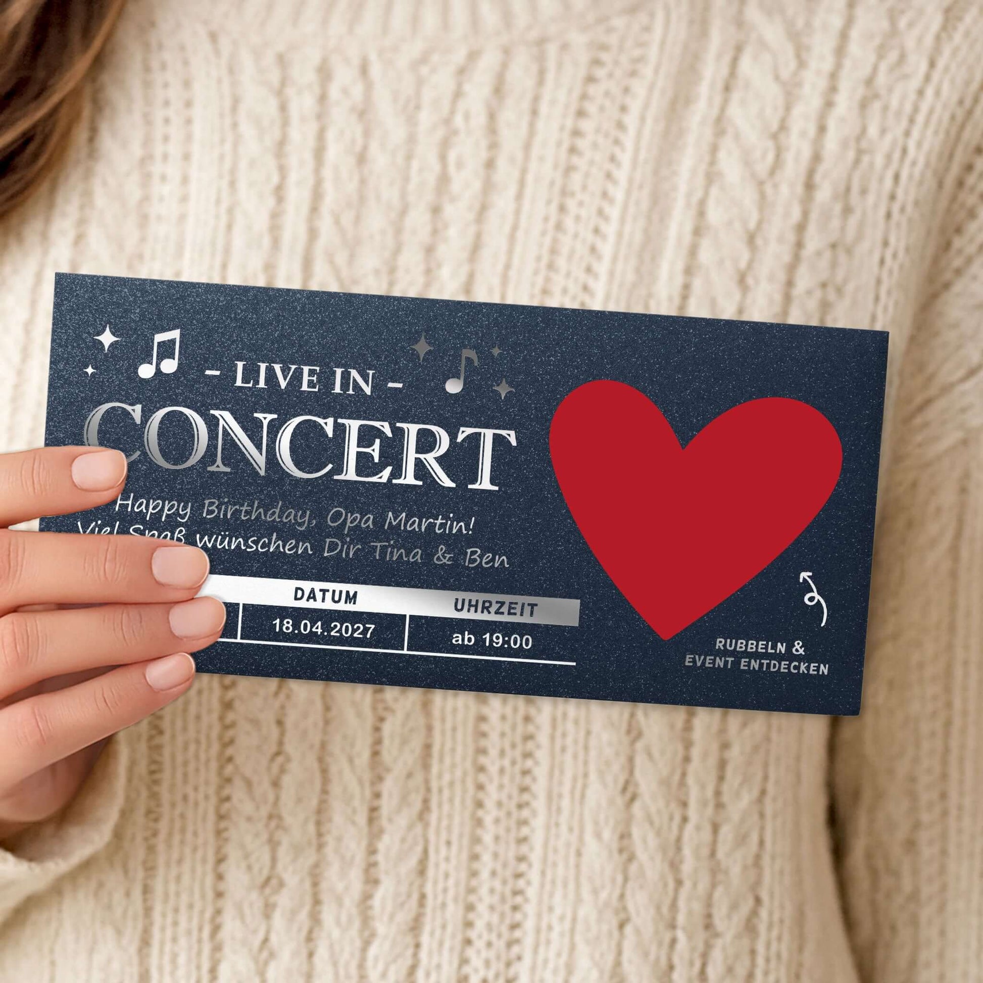 Konzert Geschenk Rubbelkarte mit personalisierter Nachricht zum Geburtstag, in Hand gehalten.
