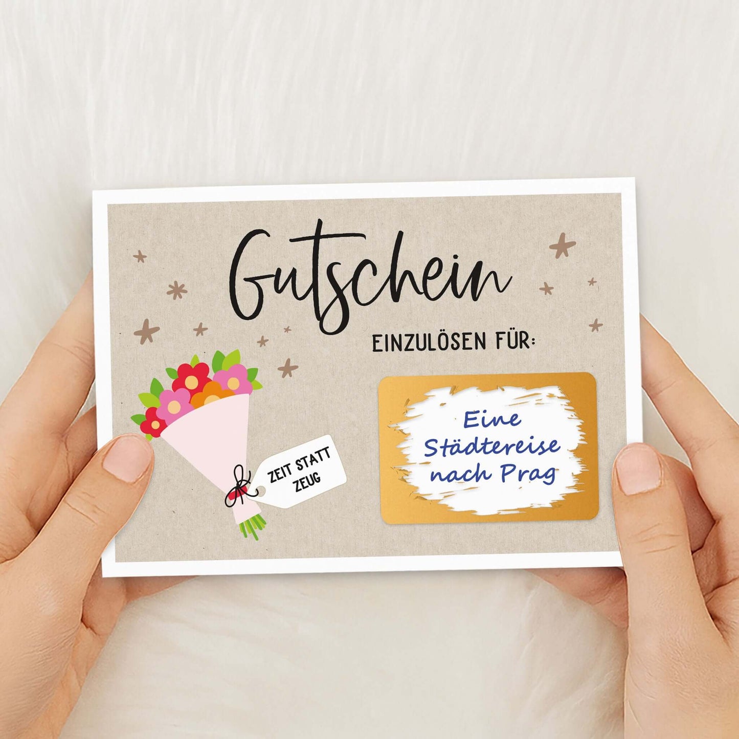 Rubbel Gutschein Blumenstrauß Gutschein mit goldfarbenem Rubbelfeld in den Händen gehalten