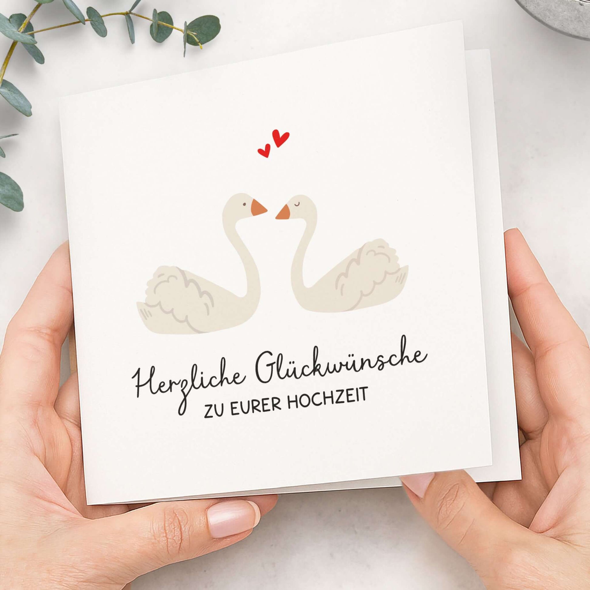 Hochzeitskarte Schwäne – Karte in Händen gehalten