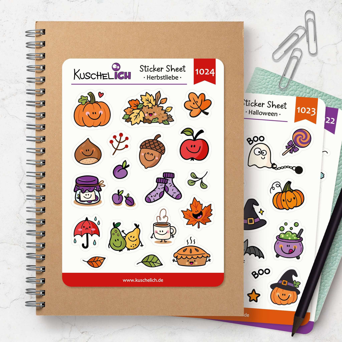 Herbst Sticker Sheet auf Kraftpapier-Notizbuch, daneben das Halloween Sticker Sheet