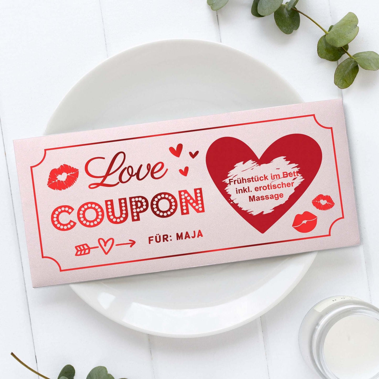Rosa Love Coupon mit roter Folierung, Rubbelherz und personalisiertem Namen auf weißem Teller
