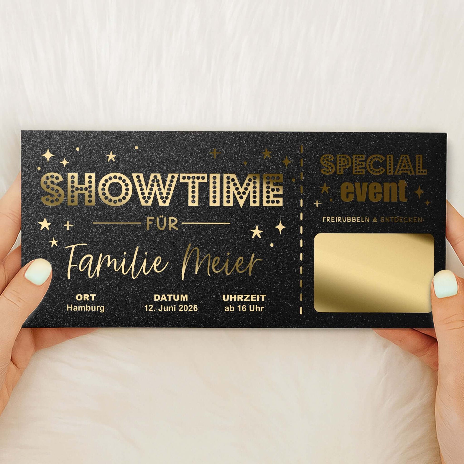 Rubbelkarte Showtime Schwarz Schimmer mit Goldfolierung und goldener Rubbelfläche, von Händen gehalten