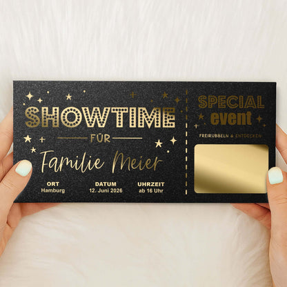 Rubbelkarte Showtime Schwarz Schimmer mit Goldfolierung und goldener Rubbelfläche, von Händen gehalten