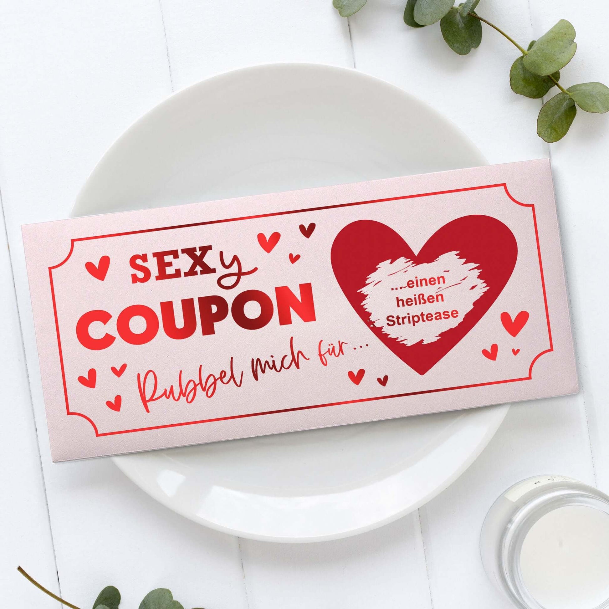 Sexy Coupon Rubbelkarte personalisiert mit herzförmigem Design und Rubbelanleitung auf Teller.